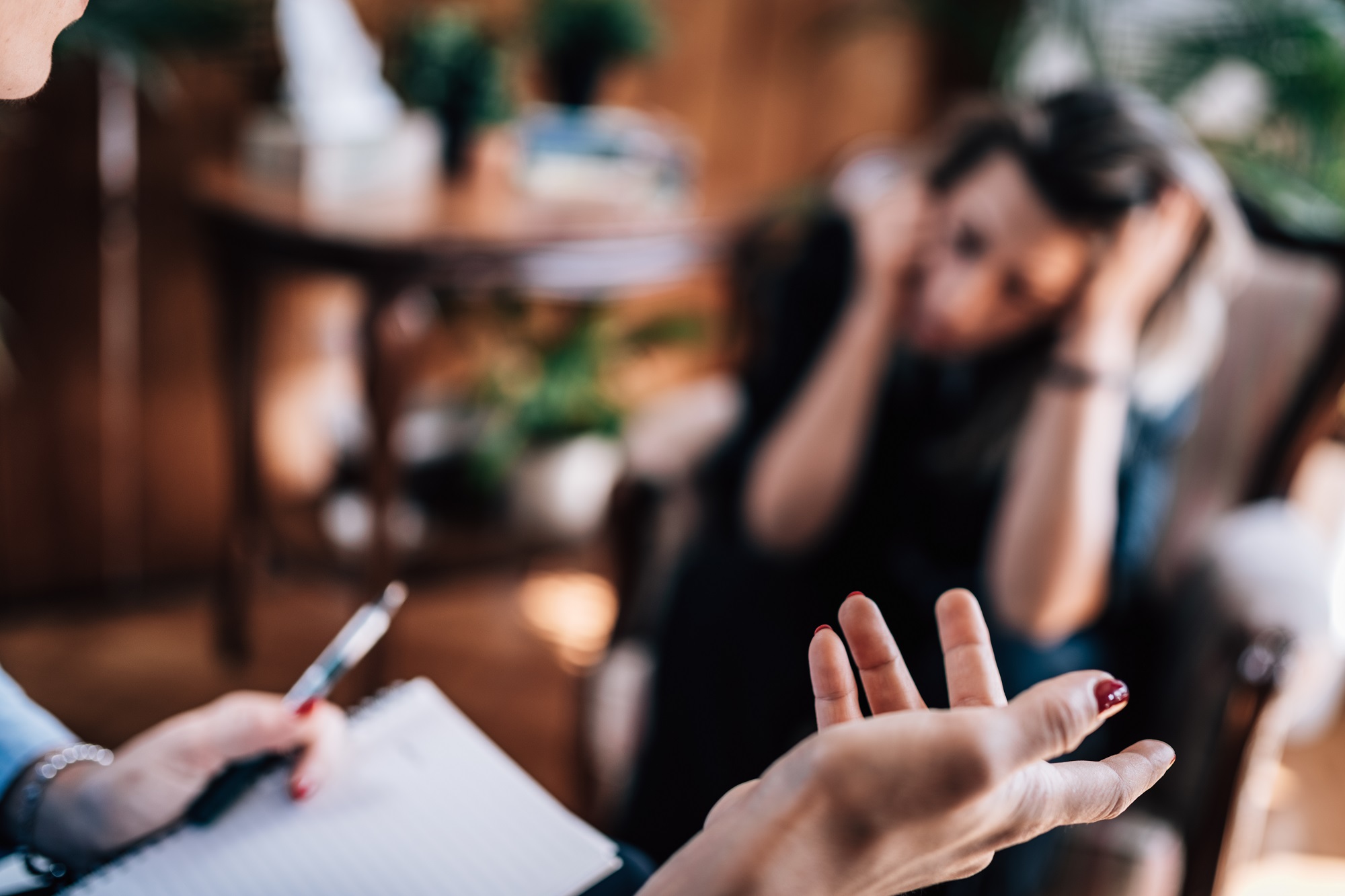 trauma therapist talking to worried woman during counselling session