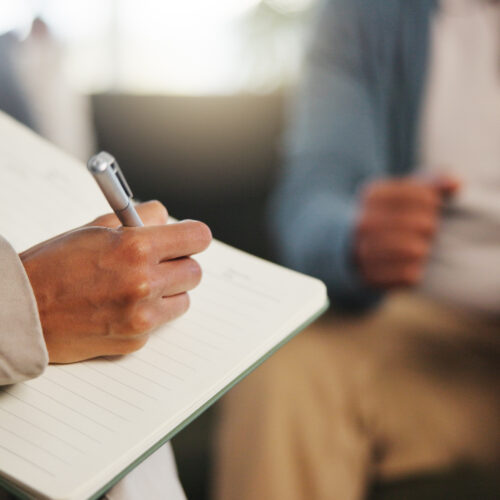 psychologist making notes during expert witness assessment