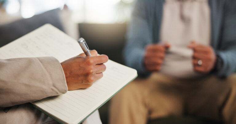 psychologist making notes during expert witness assessment